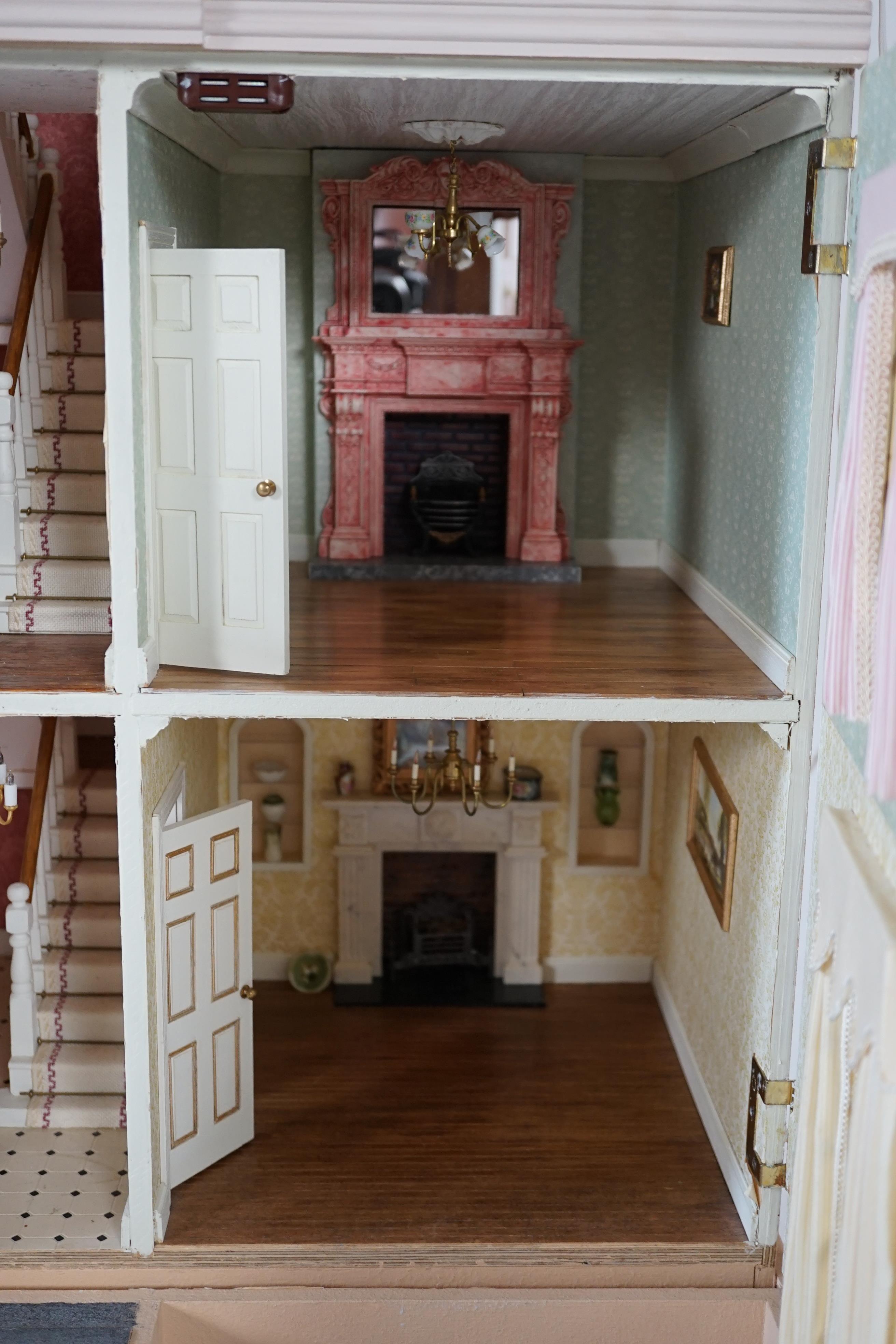 A large modern Georgian style dolls house and extensive contents, with eight fully decorated rooms on four floors, and fitted with electric lighting, removable front steps and pavement section to access basement rooms, 1